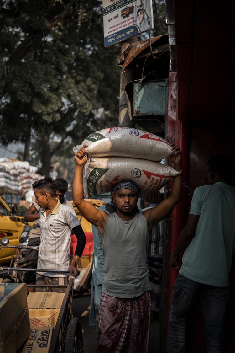 Man Carrying Bags In Town