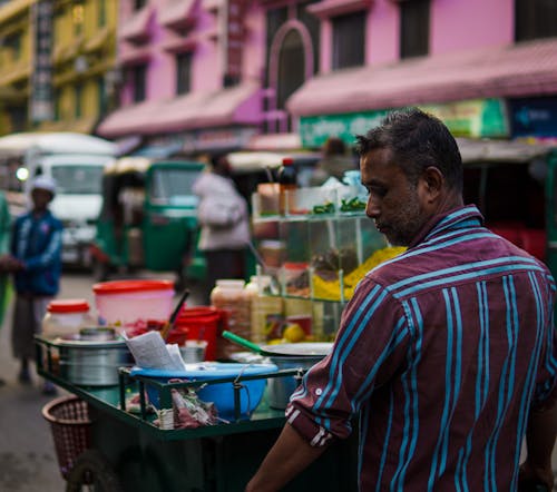 Candid Picture of a Man with a Food Cart on the Street 