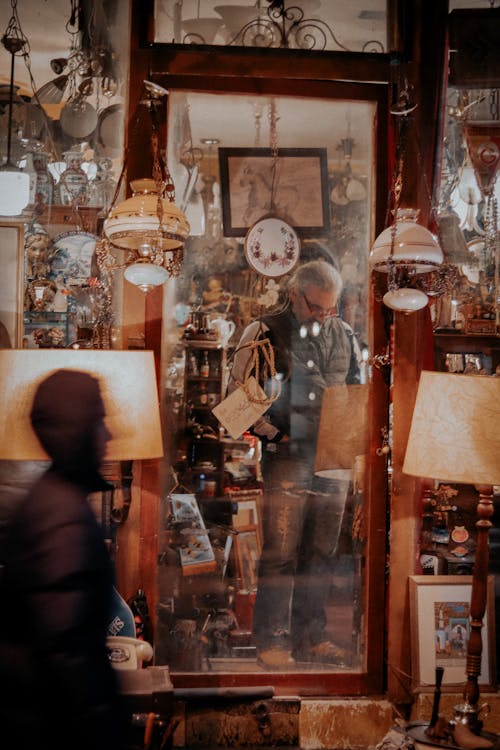 Man Standing in Store with Decorative Lamps