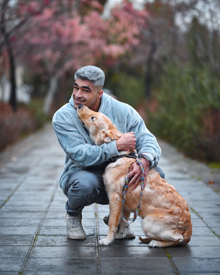 Man Posing With Golden Retriever On Sidewalk