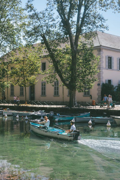 People in Motorboat on River in City