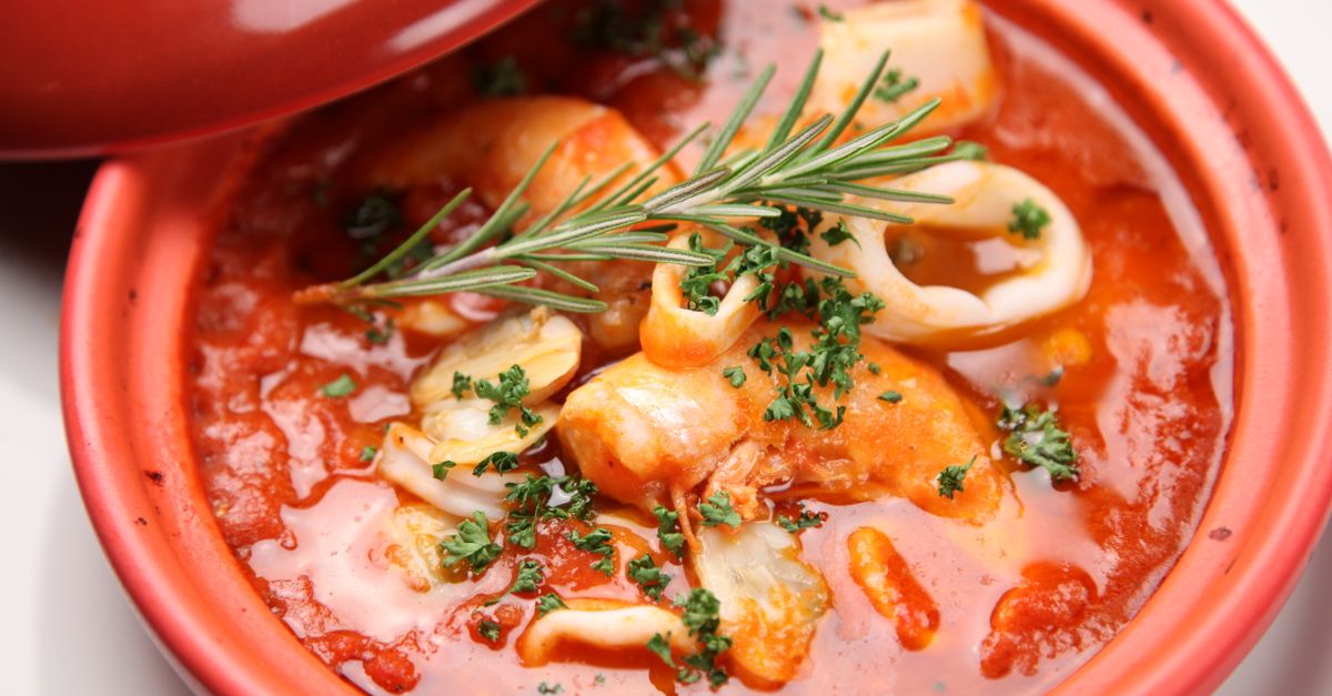 close-up of akple with okro stew garnished with red pepper and fresh herbs