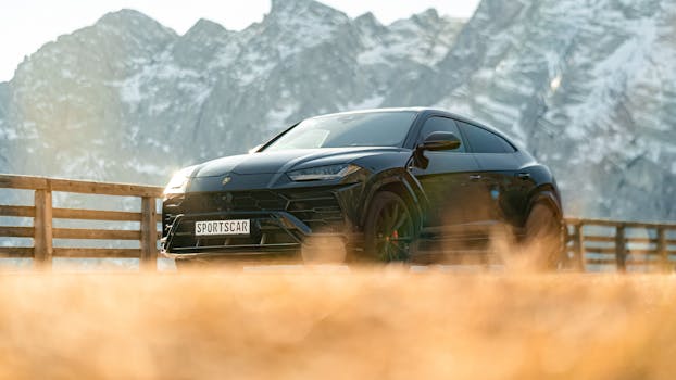 A striking black Lamborghini Urus sports car set against a stunning mountain backdrop, captured during the day.