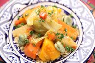 Close-up of a traditional Moroccan vegetable couscous served on an ornate plate.