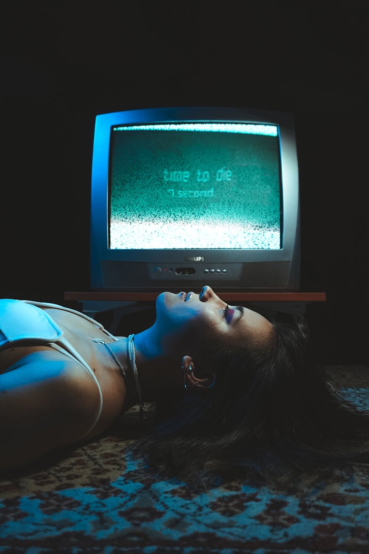 Woman Lying On Rug By Obsolete Television With Time To Die Sign