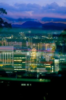 A stunning view of a city aglow with lights, captured during twilight, showcasing urban vibrancy.