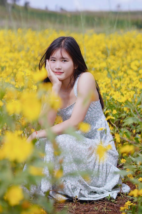 Woman in Dress Posing among Yellow Flowers