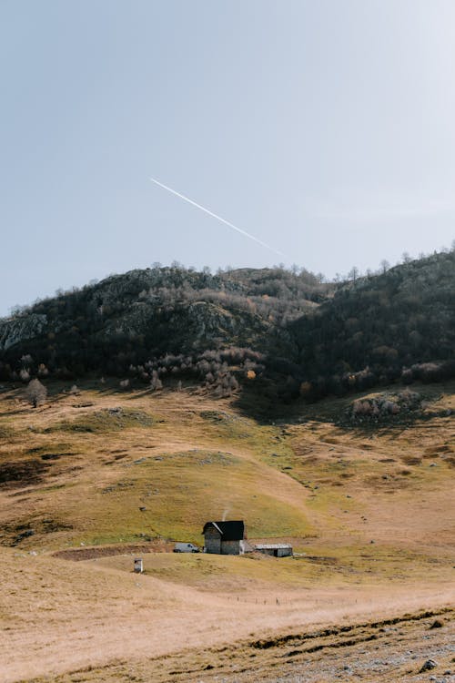 View of a House in the Countryside among Green Hills 