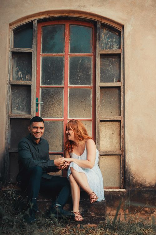 Free A cheerful couple enjoying a moment by a vintage door, capturing joy and affection. Stock Photo