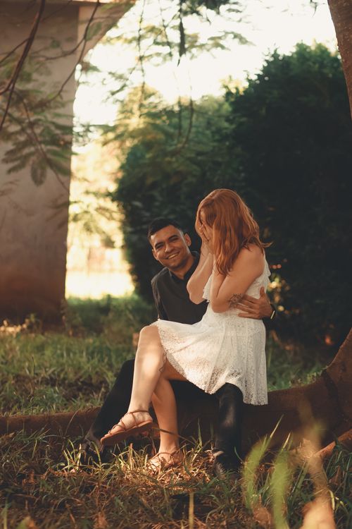 Free Smiling couple in love sitting and embracing in a lush park setting. Stock Photo