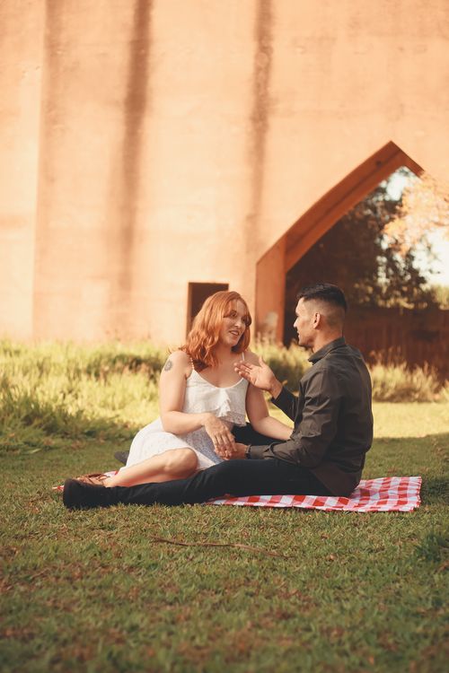 Free A couple enjoys a romantic picnic outdoors, captured in warm lighting. Stock Photo
