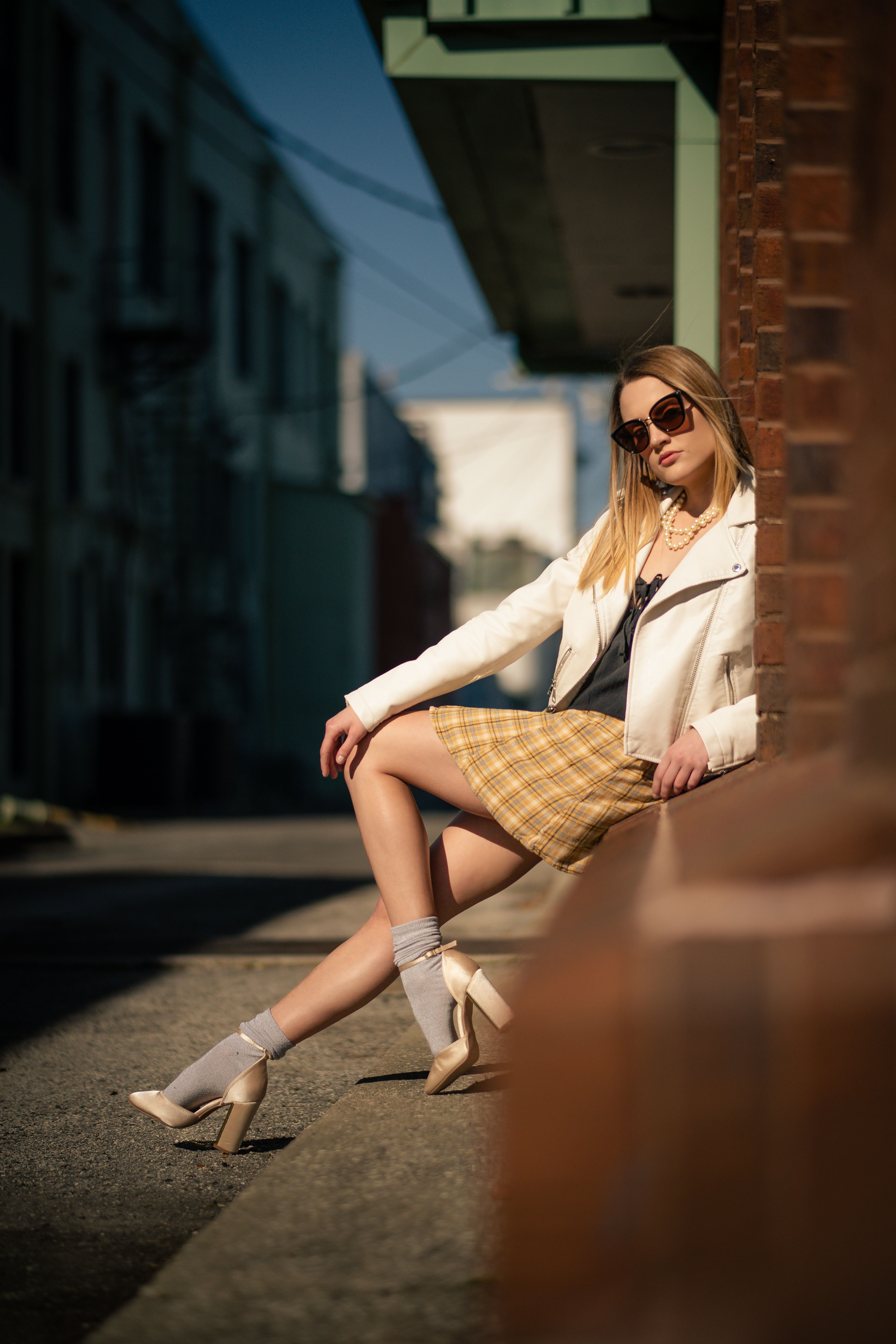 Woman Leaning Against a Brick Wall · Free Stock Photo