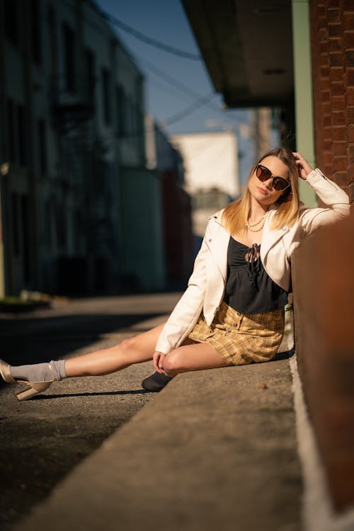 Woman Sitting on the Sidewalk in the Alley