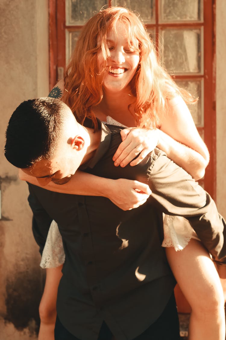 Man Carrying Laughing Woman On His Back