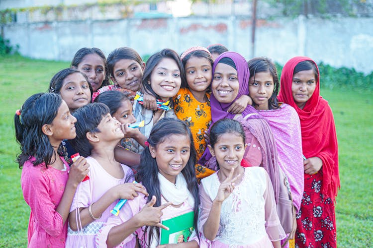 A Group Of Girls Of Different Ages Posing Together And Smiling