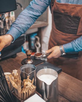 Close-up of a barista making espresso in a Nizhyn café with milk and coffee tools.