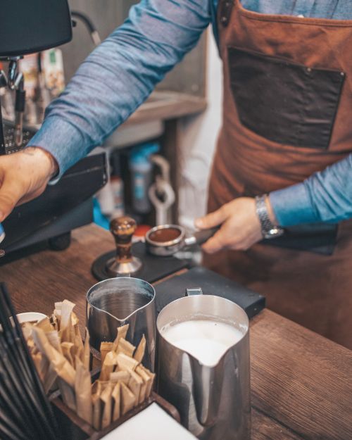 Free Close-up of a barista making espresso in a Nizhyn café with milk and coffee tools. Stock Photo