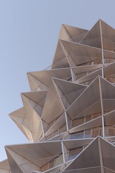 Close-up view of the modern and geometric facade of Kaktus Towers in Copenhagen against a clear blue sky.