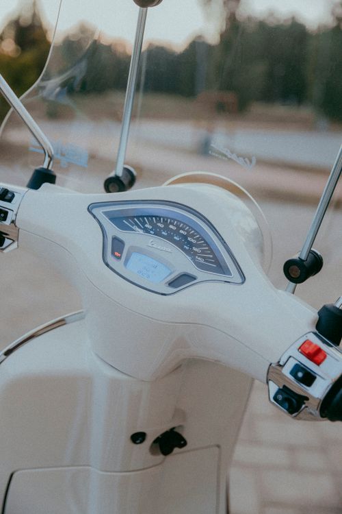 Free Close-up of a white scooter dashboard with windshield, captured outdoors. Stock Photo