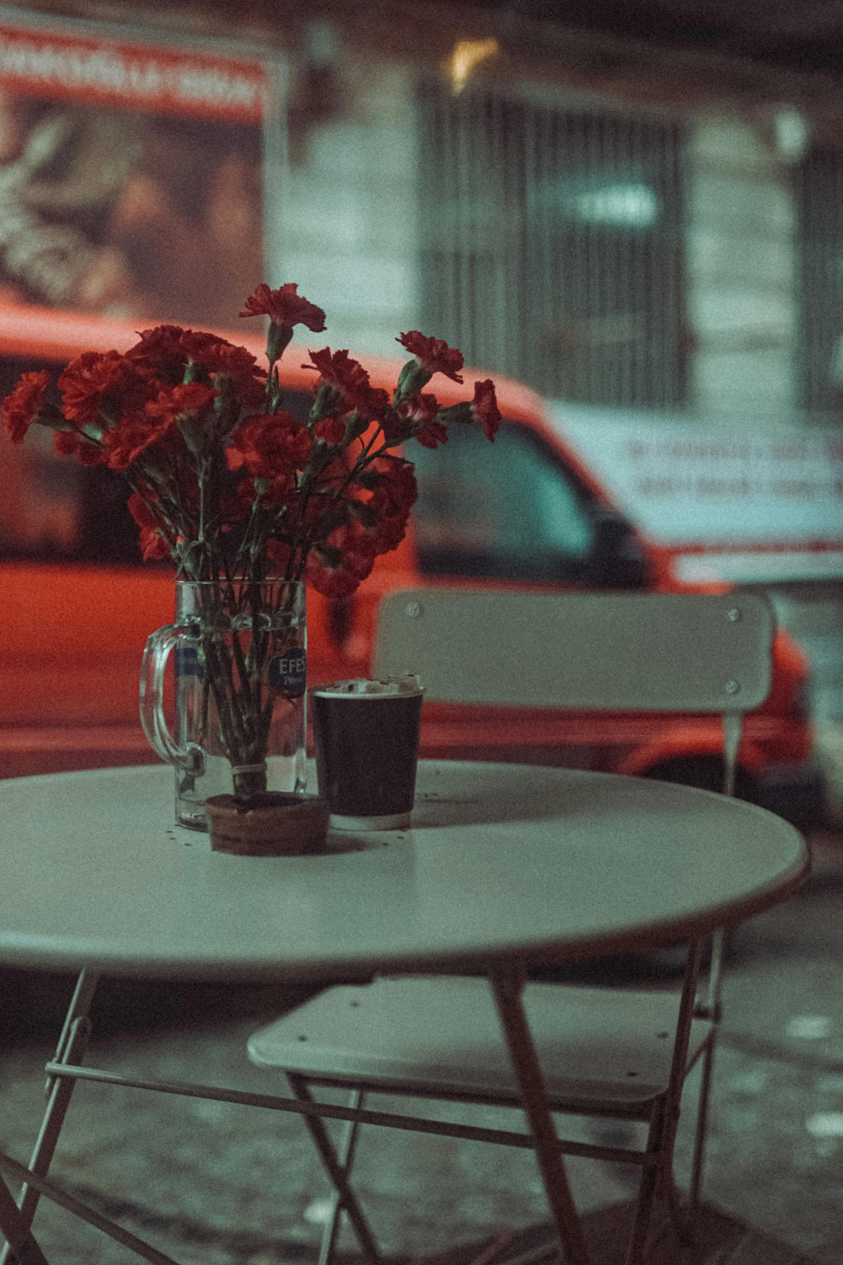 Gratuit Un Buchet De Flori într O Cană De Bere Stând Pe O Masă Pe O Terasă De Bar în Oraș  Fotografie de stoc