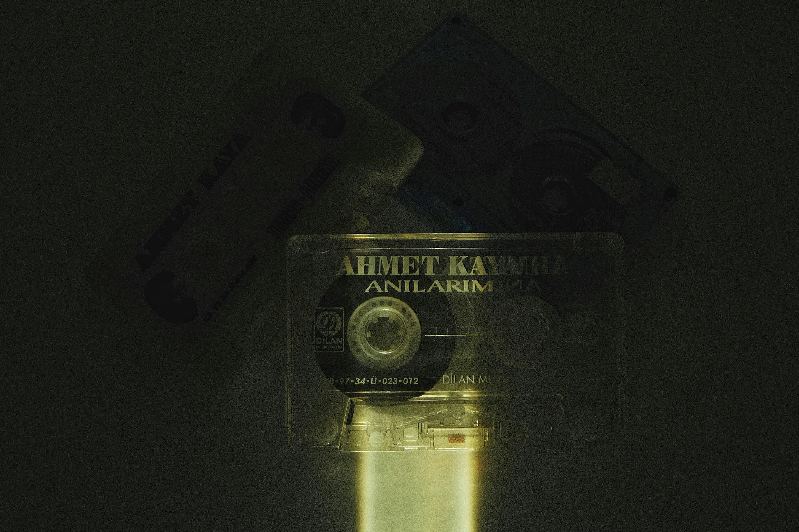Vintage cassettes arranged in the dark, illuminated by focused light, showcasing nostalgic music culture.