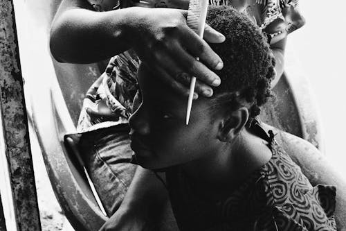 Black and White Photo of a Woman Having her Hair Combed