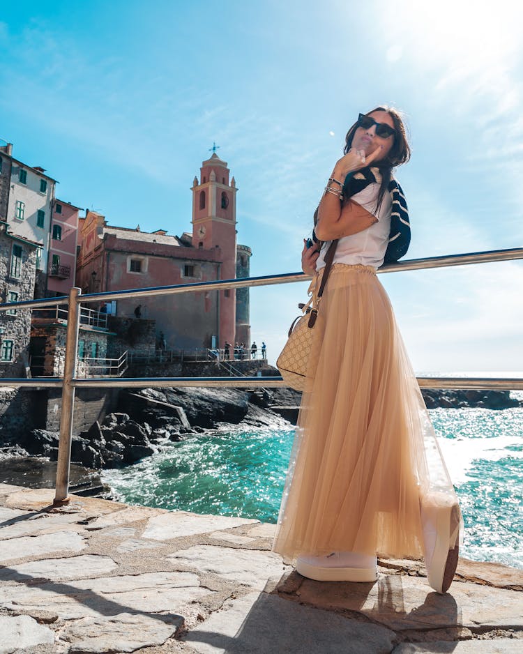 Woman In Skirt Posing On Shore In Tellaro