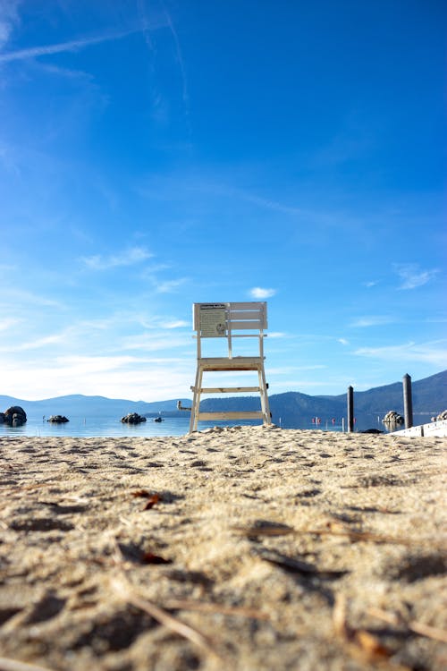 米色沙滩上的白色椅子