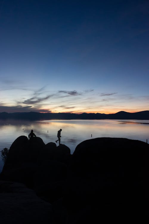 Silhouette of Person Walking on Rock