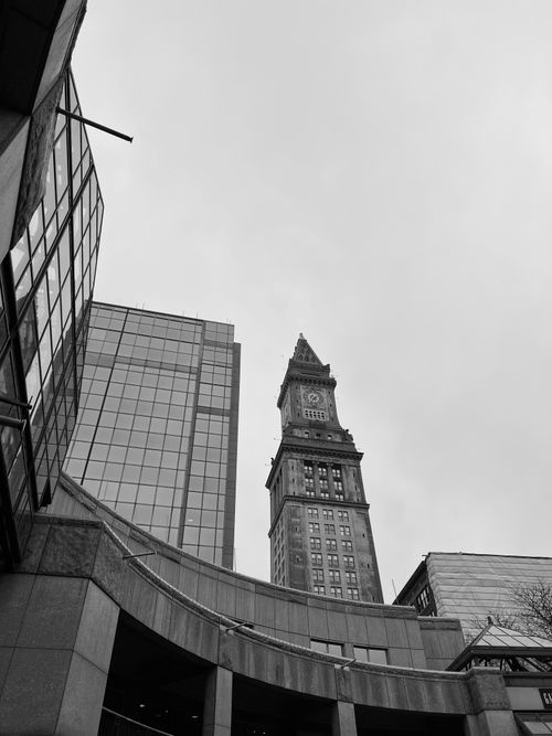 Free Striking view of a historical clock tower amidst modern high-rise buildings in a city center. Stock Photo