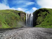 在蓝天下，瀑布在青山中倾泻而下，展现出壮丽的景色