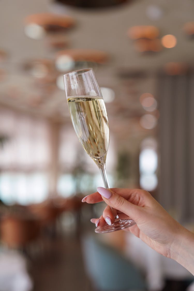 Person's Hand Holding A Glass Of Champagne 