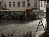 Rain falls on a city street in Bad Säckingen, Germany, showing urban life and weather.