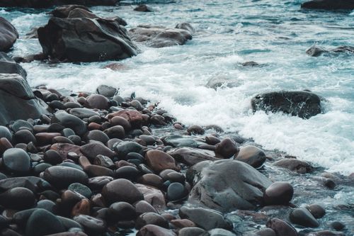 Free Calm ocean waves gently crashing on a rocky shoreline, creating a peaceful seascape. Stock Photo