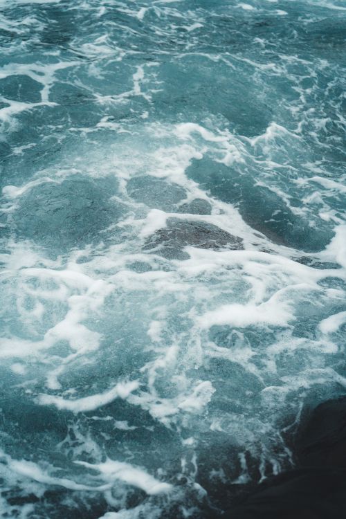 Free Blue ocean surface with white foam, captured in a dynamic vertical shot. Stock Photo