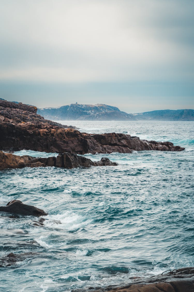 Rock Formations Extending Into Sea Shore