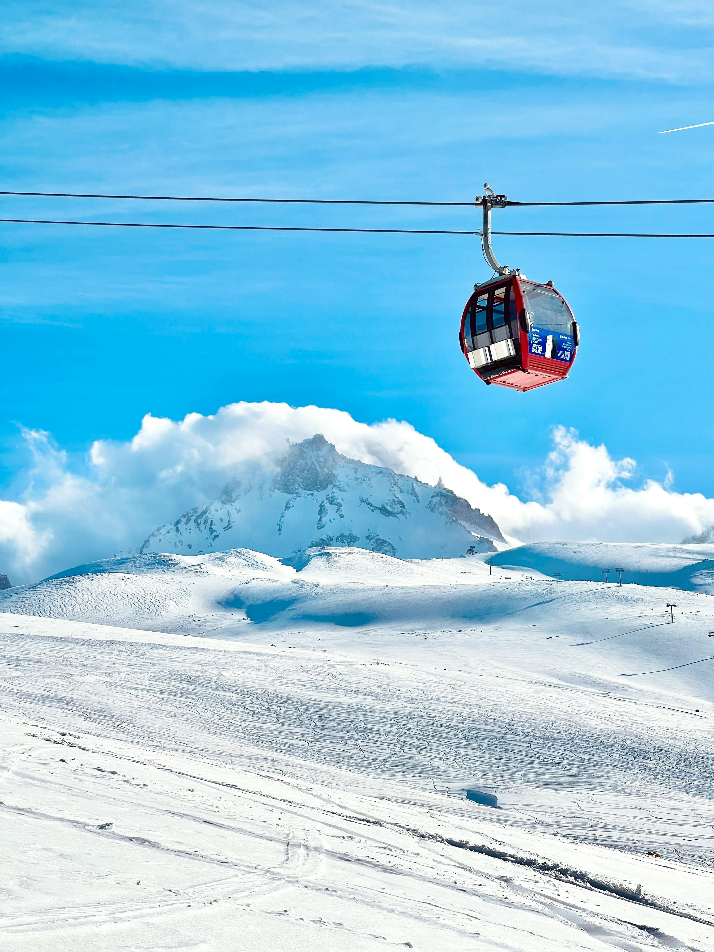 Prescription Goggle Inserts - A picturesque scene of a cable car against a snowy mountain background, perfect for winter travel themes.