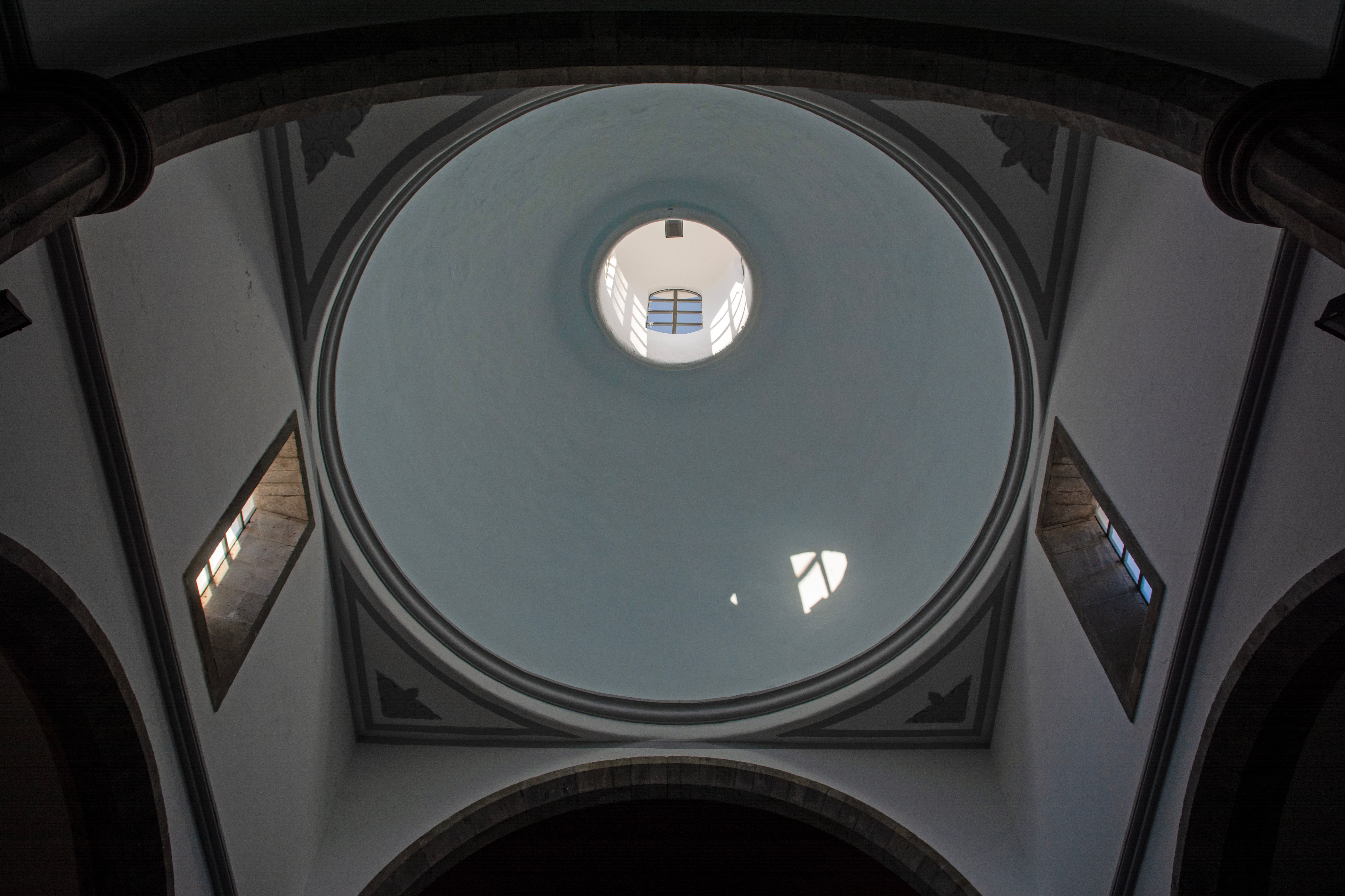 Low-angle view of a majestic dome interior in a church, showcasing architectural elegance.