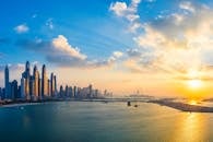 在黄金时段，迪拜天际线和海滨的壮丽景色与发光的摩天大楼反射在水面上