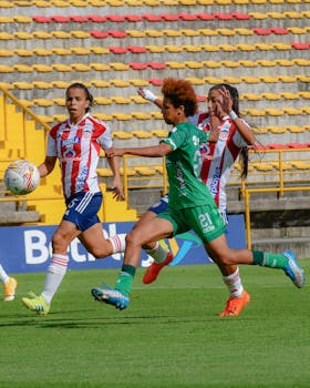 Intense action during a women's football match in a vibrant stadium setting.