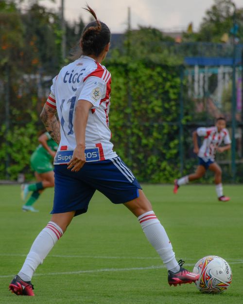 Free Women soccer players in a competitive football match, showcasing skill and team spirit. Stock Photo