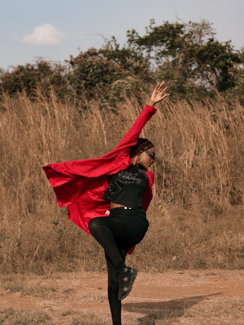 Young Woman Jumping on a Grass Field 