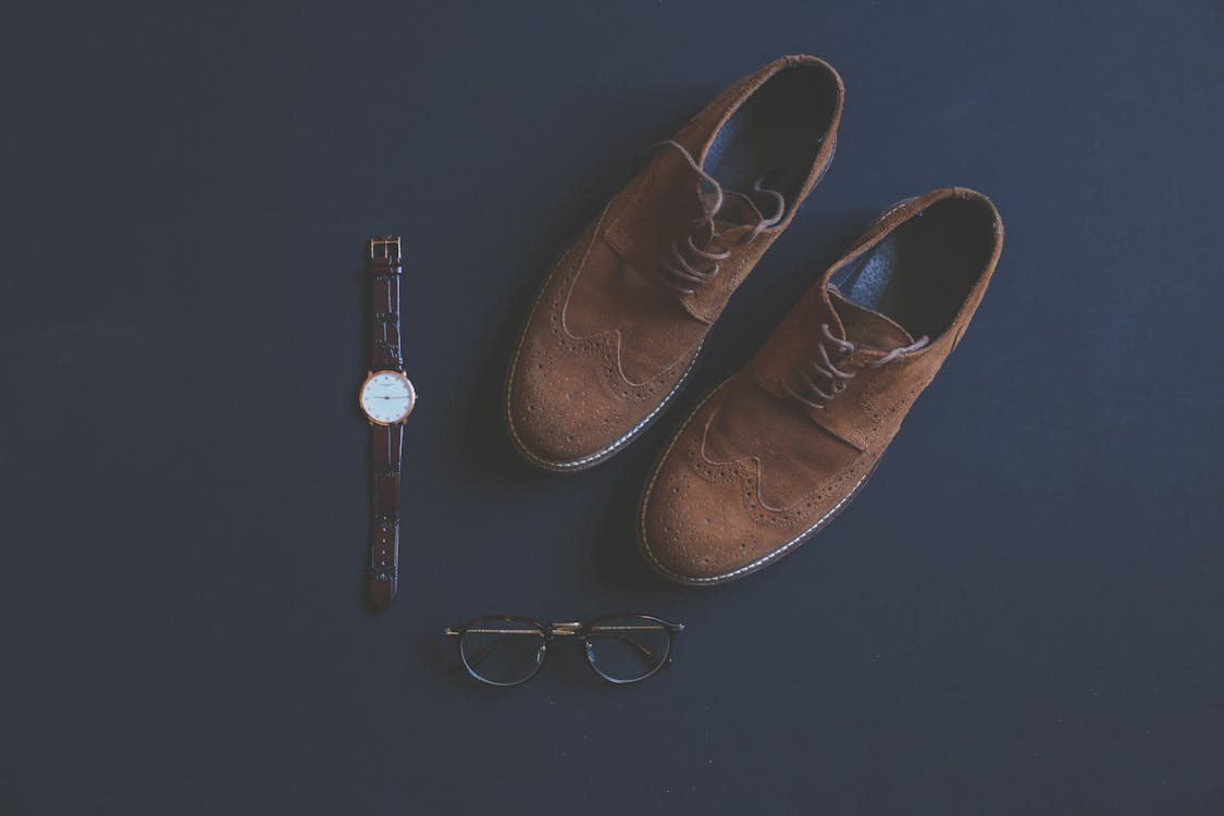 Free Brown Leather Brogue Shoes Beside Eyeglasses and Watch Stock Photo