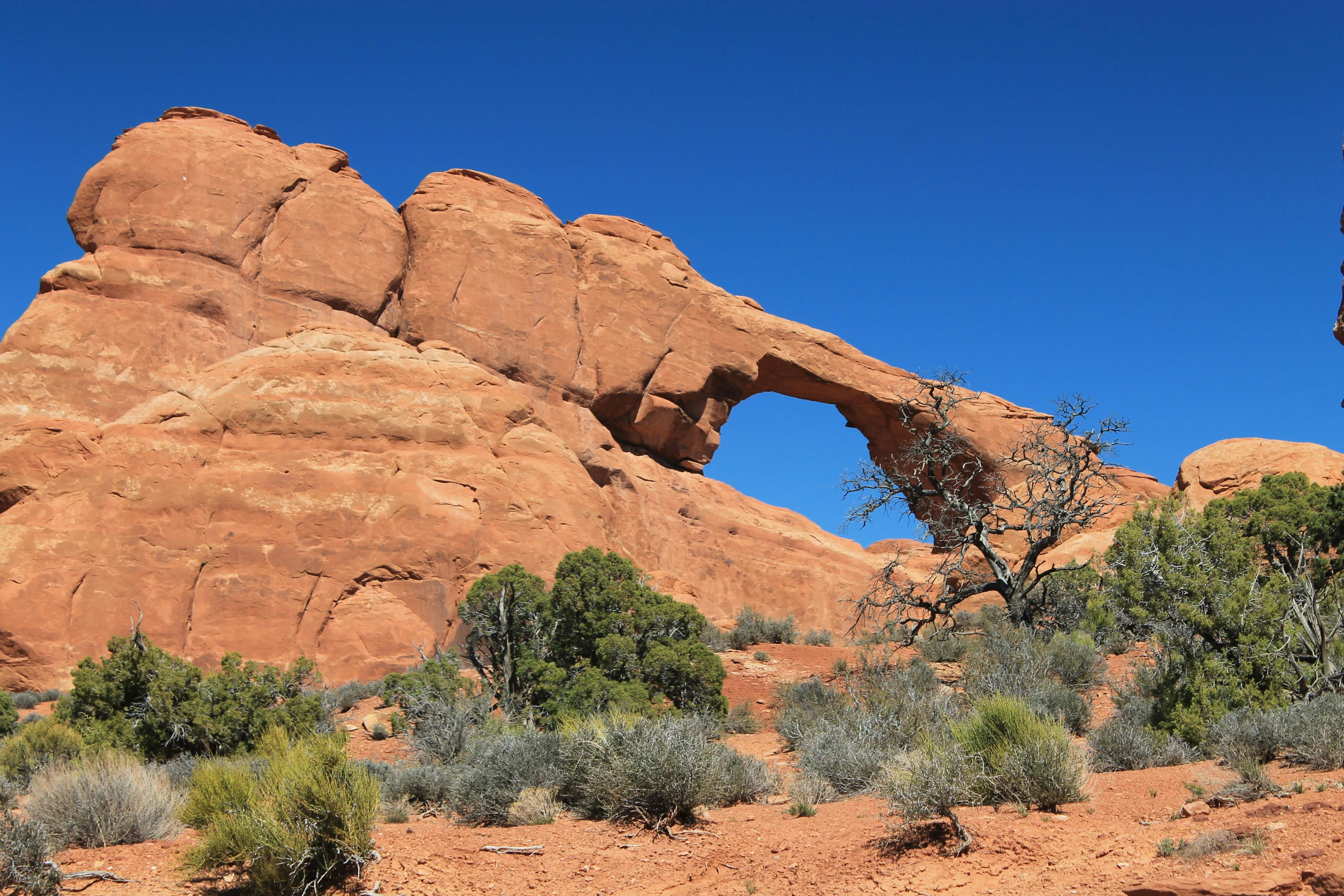 Arc Rock Formation Under Blue Clouds during Daytime