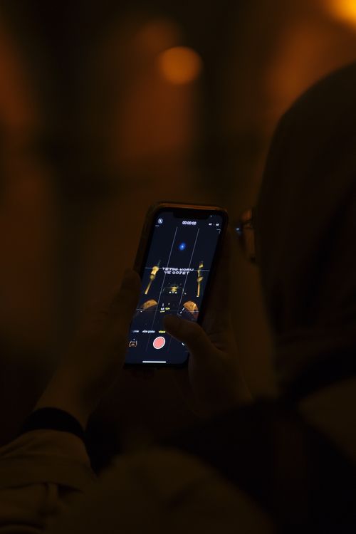 Free A person recording with a smartphone in a dimly lit environment, capturing details on screen. Stock Photo
