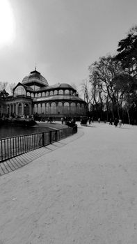 Elegant black and white image capturing Madrid's Crystal Palace in a serene park setting.