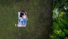 一对浪漫的情侣从上方俯瞰，在郁郁葱葱的迪拜公园里享受休闲时光