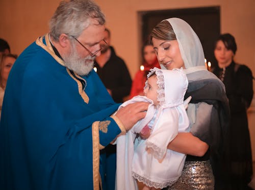 Priest near Mother with Daughter on Orthodox Baptism Ceremony