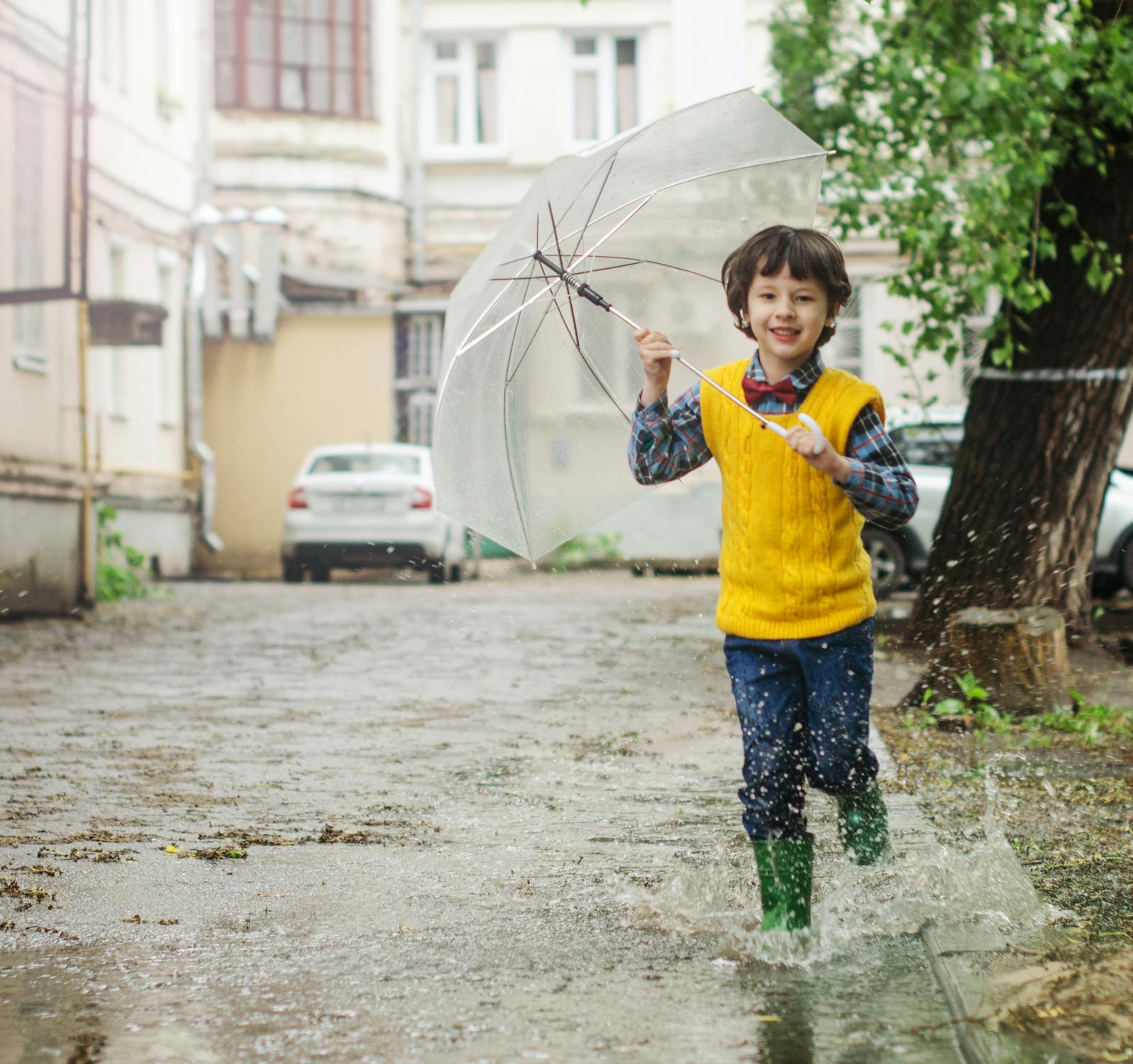 快乐的孩子宝贝男孩穿着胶靴和雨伞在水坑里跳秋天走路照片摄影图片_ID:324337495-Veer图库