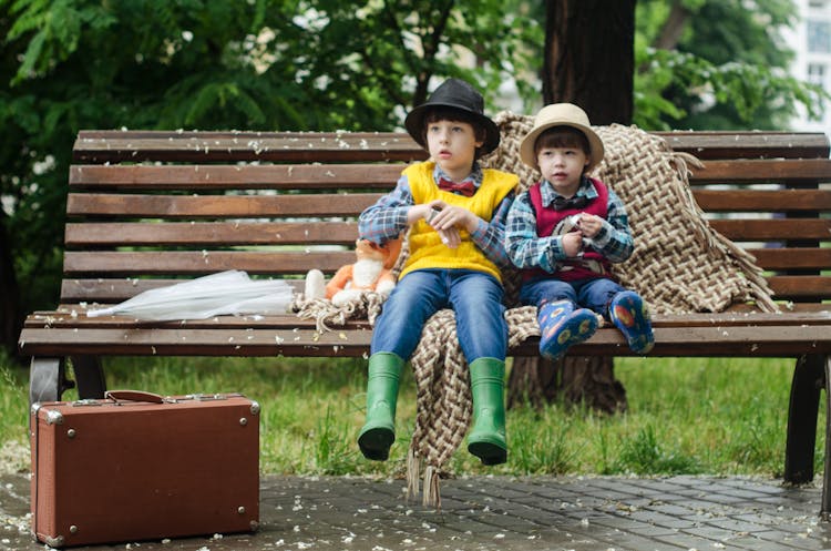 Two Kids Sitting On Brown Bench